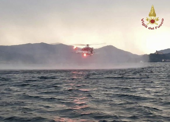 In this image released by the Italian firefighters a helicopter search for missing after a tourist boat capsized in a storm on Italy&#039;s Lago Maggiore in the northern Lombardy region, Sunday, May 2 ...