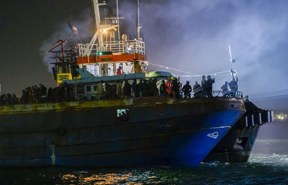 A fishing boat with some 500 migrants enters the southern Italian port of Crotone, early Saturday, March 11, 2023. The Italian coast guard was responding to three smugglers boats carrying more than 1, ...