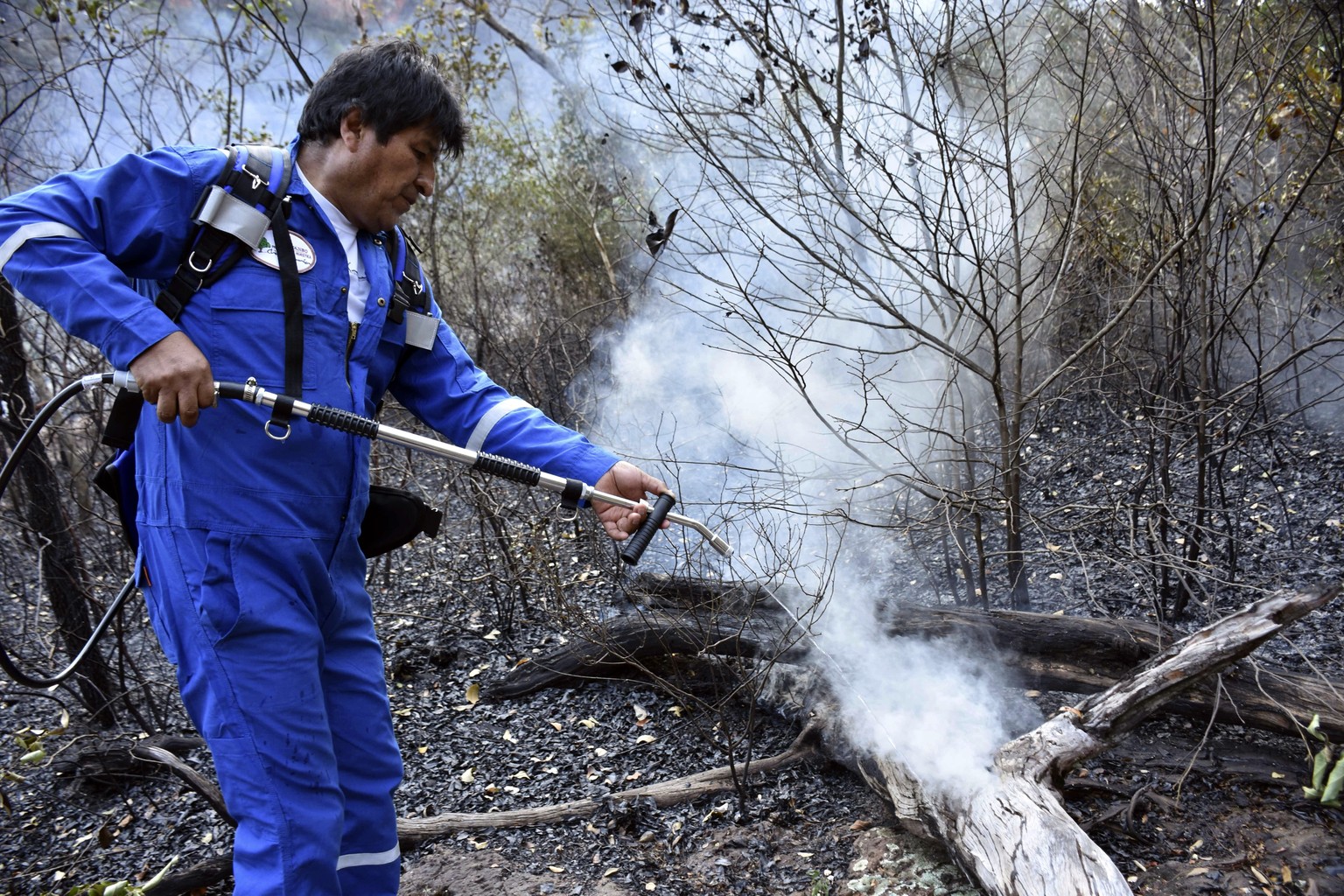 In this photo courtesy of Bolivia&#039;s Communication Ministry press office, Bolivian President Evo Morales sprays water at a fire on the outskirts of Robore, Bolivia, Tuesday, Aug. 27, 2019. Morales ...