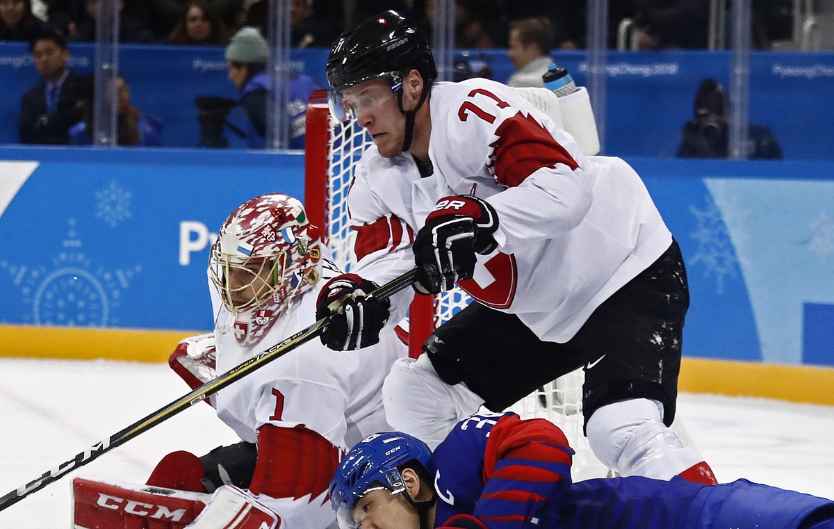 epa06535333 Jonas Hiller (L) and Enzo Corvi (R) of Switzerland block a shot against Woosang Park (C) of Republic of Korea during the men's preliminary round inside the Gangneung Hockey Centre at  ...