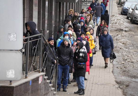 FILE - People stand in line to withdraw U.S. dollars and Euros from an ATM in St. Petersburg, Russia, Friday, Feb. 25, 2022. In the days since the West imposed sanctions on Russia over its invasion of ...