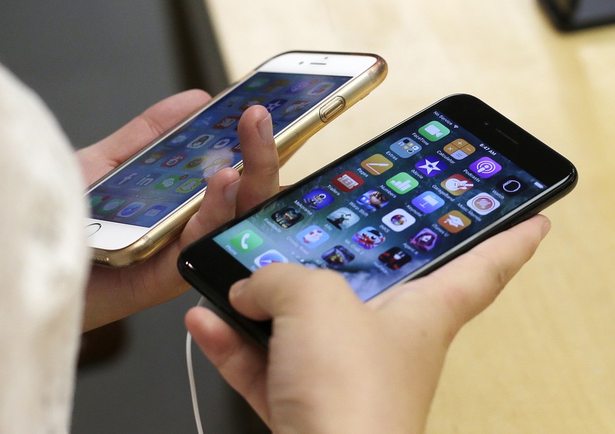 FILE - In this Sept. 16, 2016 file photo, a customer compares a jet black iPhone 7, right, with her iPhone 6 at the Apple Store in Chicago. Apple Inc.’s iPhones are assembled in China and count as a C ...