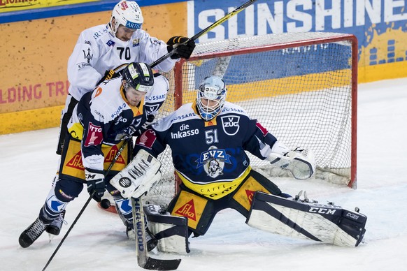 Zugs Thomas Thiry, links, und Zugs Torhueter Tobias Stephan behaupten sich gegen Luganos Matteo Romanenghi, hinten, waehrend dem Eishockey-Meisterschaftsspiel der National League zwischen dem EV Zug u ...