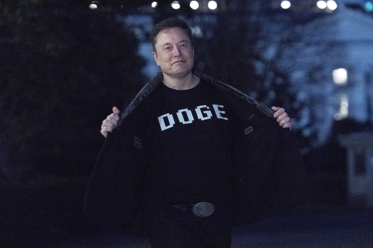 Elon Musk flashes his t-shirt that reads "DOGE" to the media as he walks on South Lawn of the White House, in Washington, Sunday, March 9, 2025. (AP Photo/Jose Luis Magana)
Elon Musk