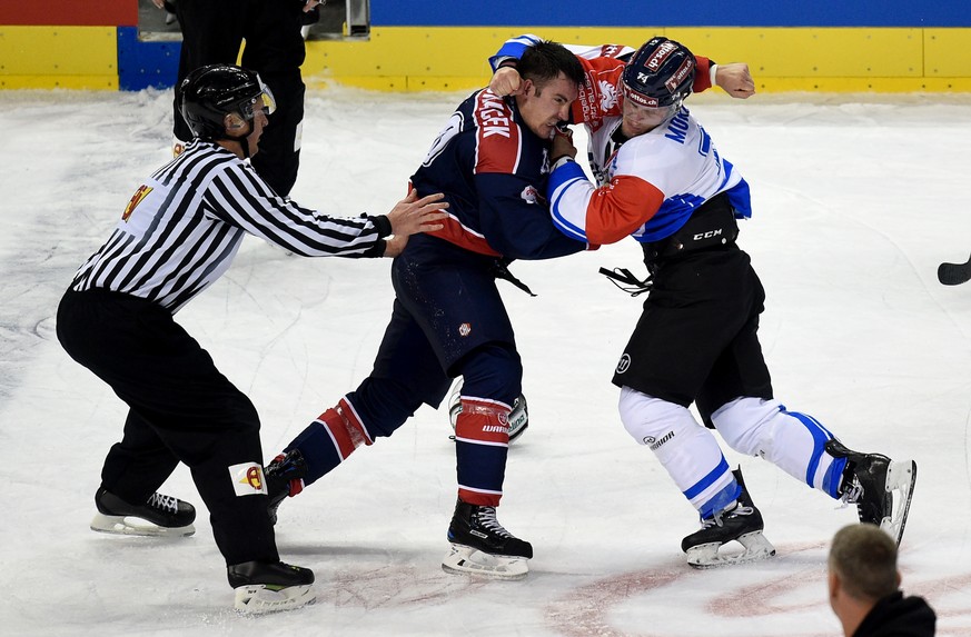 Berlin&#039;s Spencer Machacek, left, fights againt Zug&#039;s Johann Morant, during the Champions League round of 32 ice hockey match between Eisbaeren Berlin and EV Zug, in Berlin, Germany, on Tuesd ...