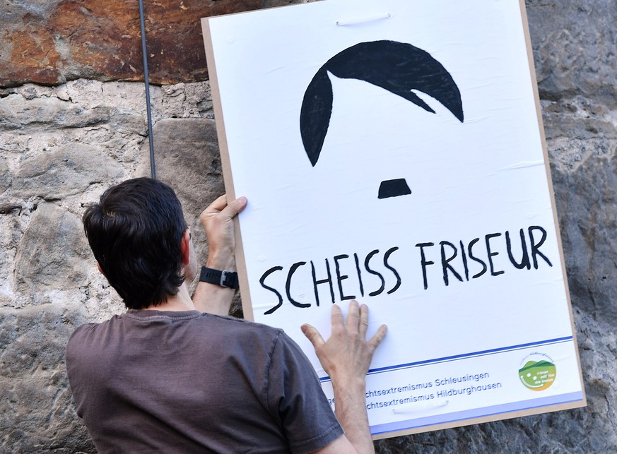 Ein Plakat mit der Aufschrift «Scheiss Friseur» wird am 11.07.2017 in Themar (Thueringen) an der Stadtmauer befestigt. Am 15.07.2017 soll in Themar das vielleicht groesste Rechtsrock-Konzert in Deutsc ...