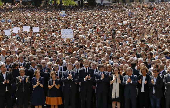 King Felipe of Spain, center, Prime Minister Mariano Rajoy, center left, and Catalonia regional President Carles Puigdemont, center right, join people gathered for a minute of silence in memory of the ...