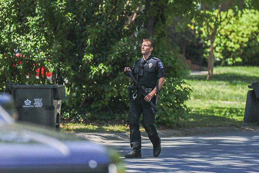 A Charlotte Mecklenburg police officer carries a gun as he walks in the neighborhood where an officer-involved shooting took place in Charlotte, N.C., Monday, April 29, 2024. Police in North Carolina  ...