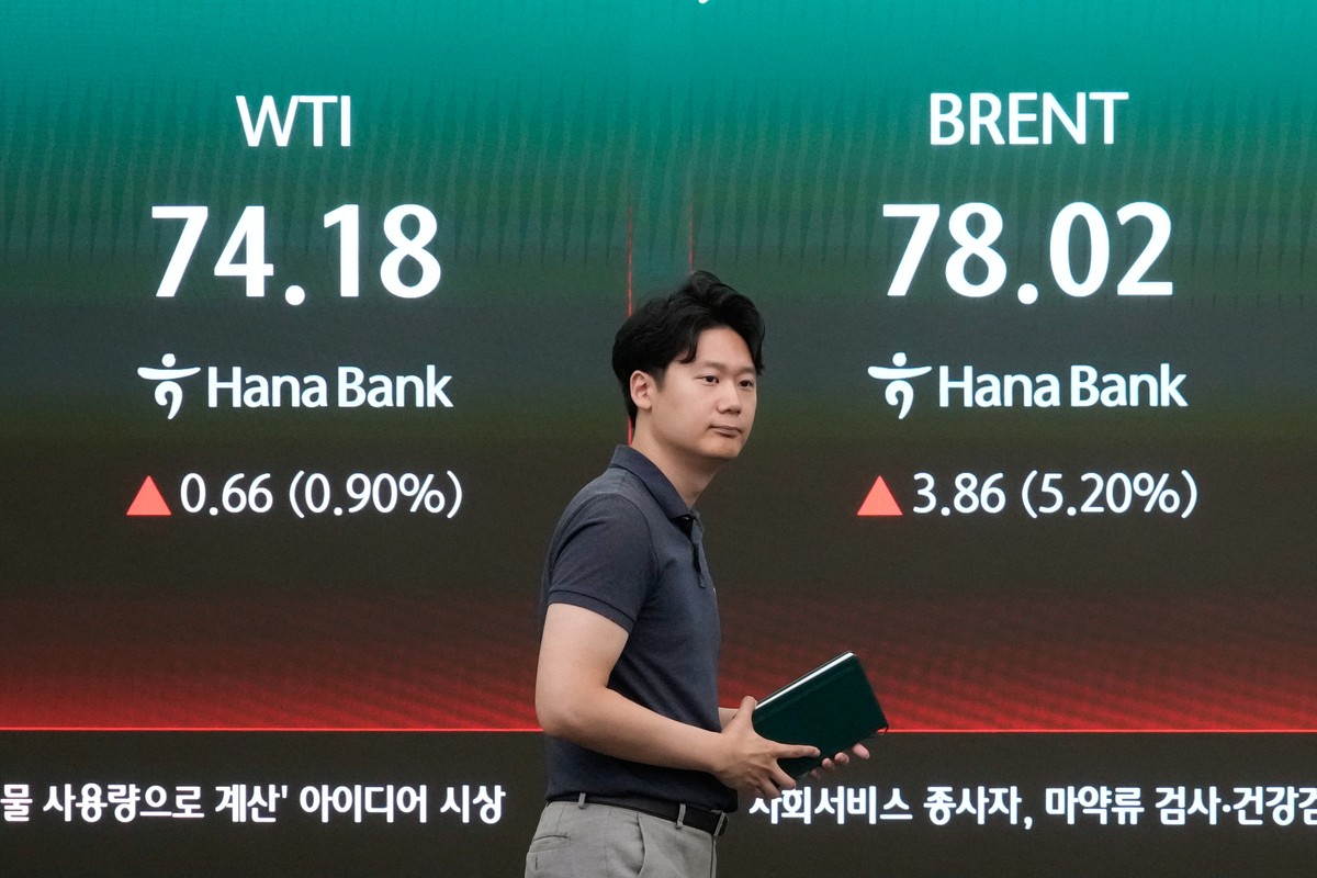 A currency trader passes by a screen showing international oil prices at the foreign exchange dealing room of the Hana Bank headquarters in Seoul, South Korea, Thursday, July 9, 2026. (AP Photo/Ahn Yo ...