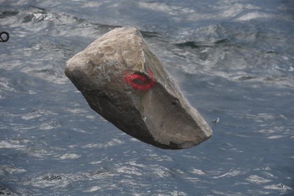 26.07.2020, Mecklenburg-Vorpommern, Sassnitz: Ein Stein f�llt in die Ostsee, w�hrend Greenpeace-Aktivisten vom Greenpeace-Schiff "Beluga II" aus vor der Insel R�gen gro�e Granitbl�cke im Mee ...