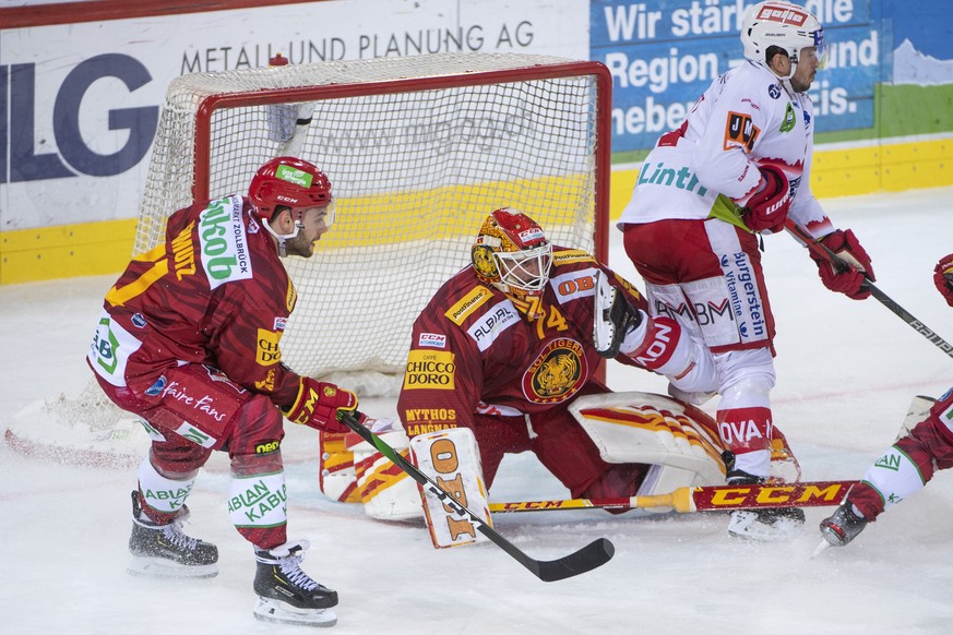 Tigers, Julian Schmutz, links, und Tigers Goalie, Ivars Punnenovs , Mitte, kaempfen um den Puck, gegen Rapperswils, Corsin Casutt, rechts, waehrend dem Meisterschaftsspiel der National League, zwische ...