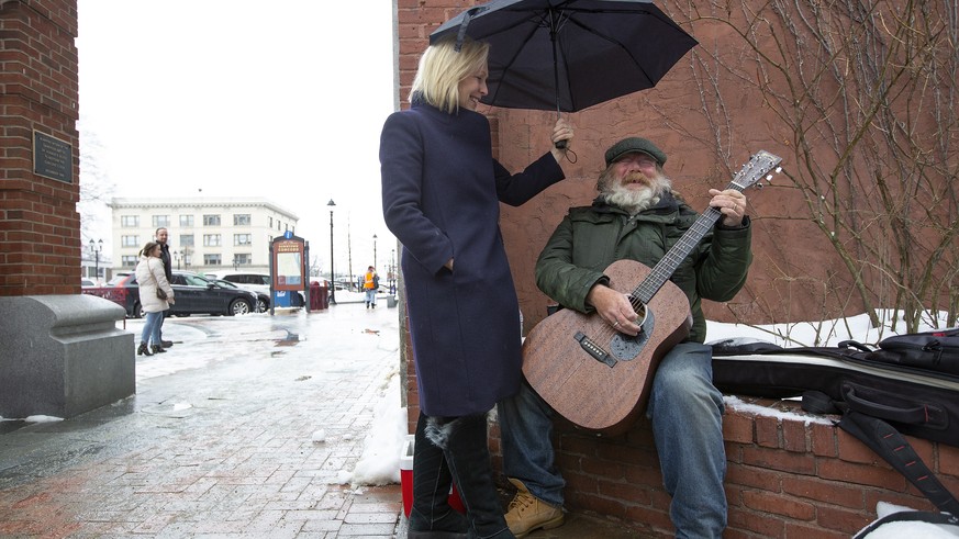 epa07445735 (FILE) - Senator Kirsten Gillibrand (L) sings with Kevin Clark (R) on Main Street while on a walking tour of businesses in downtown Concord, New Hampshire, USA 15 February 2019 (Issued 17  ...