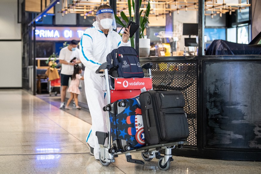 epa09610670 A traveler wearing personal protective equipment (PPE) arrives at Sydney International Airport in Sydney, New South Wales (NSW), Australia, 29 November 2021. The Omicron variant of SARS-Co ...