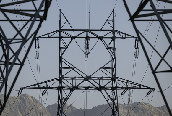 Ein Starkstrommasten auf der Linie Airolo-Mettlen der nationalen Strom Netzgesellschaft Swissgrid auf der obersten Ebene und die Starkstromleitung der SBB auf der unteren Ebene, steht mitten in der Ge ...