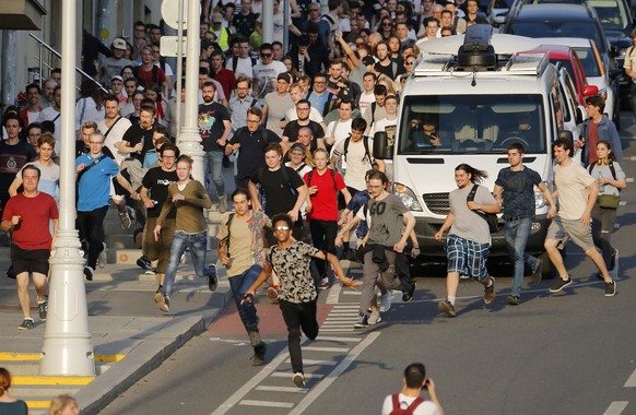 Protesters run away from the police during an unsanctioned rally in the center of Moscow, Russia, Saturday, July 27, 2019. Russian police are clashed with demonstrators and have arrested some hundreds ...