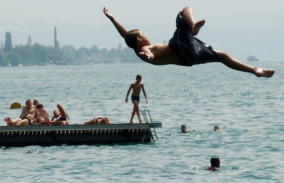 Bei Temperaturen um die 35 Grad geniesst ein Badegast am Mittwoch, 6. August 2003, in der Badi Tiefenbrunnen in Zuerich einen Sprung ins kalte Nass. Das heisse Wetter soll laut den Vorhersagen noch ei ...