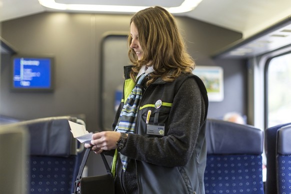 The BLS ticket inspector checks the passengers&#039; tickets in the train from Brig to Berne, Switzerland, pictured on May 30, 2013, on the railway line Berne-Goppenstein-Berne of the BLS, a Swiss rai ...