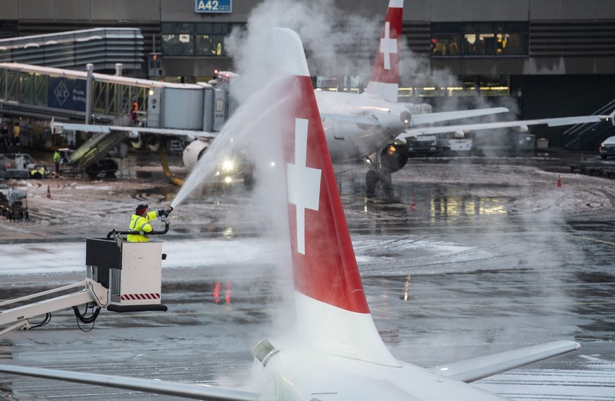 Ein Flughafen-Mitarbeiter enteist ein Flugzeug der Swiss, aufgenommen am Flughafen in Zuerich am Samstag, 05. Januar 2019. (KEYSTONE/Ennio Leanza)