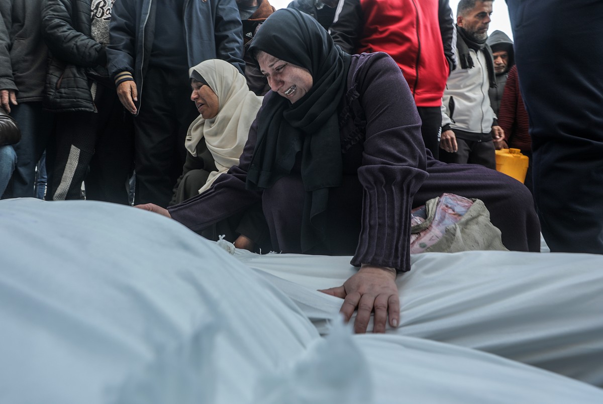 epa11825818 A Palestinian woman mourns over the covered bodies of the members of a Palestinian family killed in an Israeli airstrike, at Al Aqsa Martyrs Hospital in Deir Al Balah town, central Gaza St ...