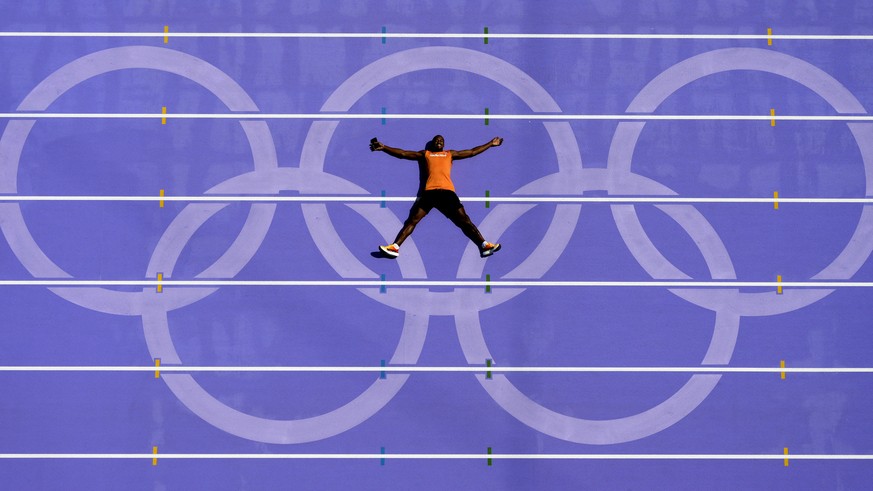 An athlete from the Netherlands lays on the track after a practice session at the 2024 Summer Olympics, Thursday, Aug. 1, 2024, in Saint-Denis, France. (AP Photo/David J. Phillip)