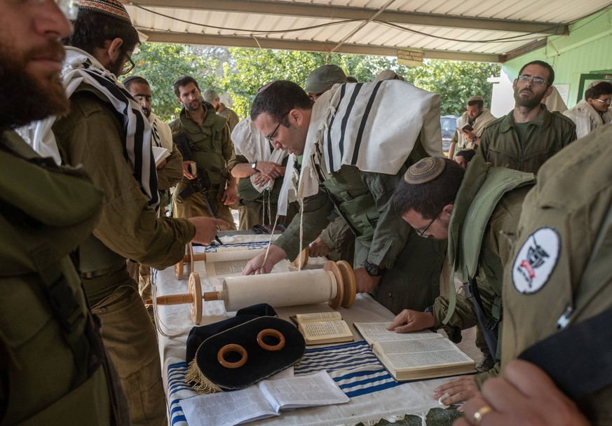 Israeli defense Forces IDF soldiers perform morning prayers on a staging area at the community of Be eri very close to the Gaza Strip border on October 14, 2023. Be eri was the scene of intense slaugh ...
