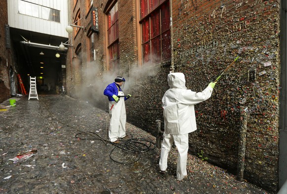Fernando Soberania, left, and Javier Ramirez, right, work to clean layers of gum from Seattle&#039;s famous &quot;gum wall&quot; at Pike Place Market, Tuesday, Nov. 10, 2015. Tourists and locals have  ...