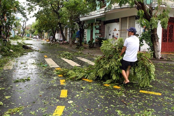 epa10210839 A handout photo made available by Vietnam News Agency shows a man cleaning up a street in Da Nang, Vietnam, 28 September 2022. Typhoon Noru has weakened to a tropical storm and made landfa ...