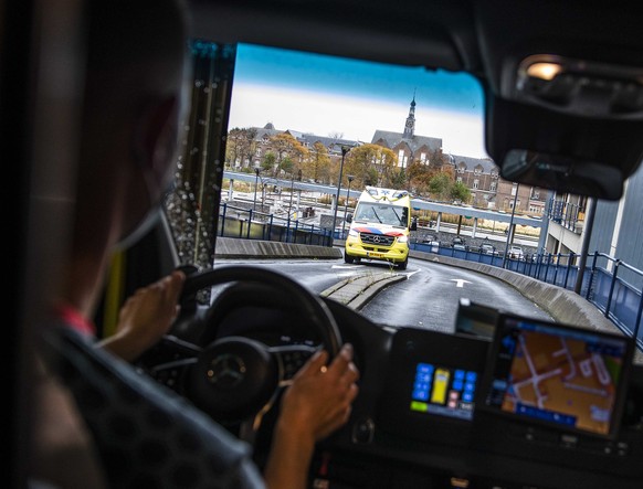 epa08783775 Ambulance employees in an ambulance leave from the RAV Hollands Midden to the LUMC hospital in in Leiden, The Netherlands, 29 Octocer 2020. The hospital is scaling down planned regular car ...