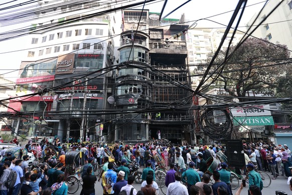 epa11190033 People gather outside the commercial building on Bailey Road in Dhaka, Bangladesh, 01 March 2024. At least 43 people have died after a fire engulfed a commercial building in Dhaka���s Bail ...