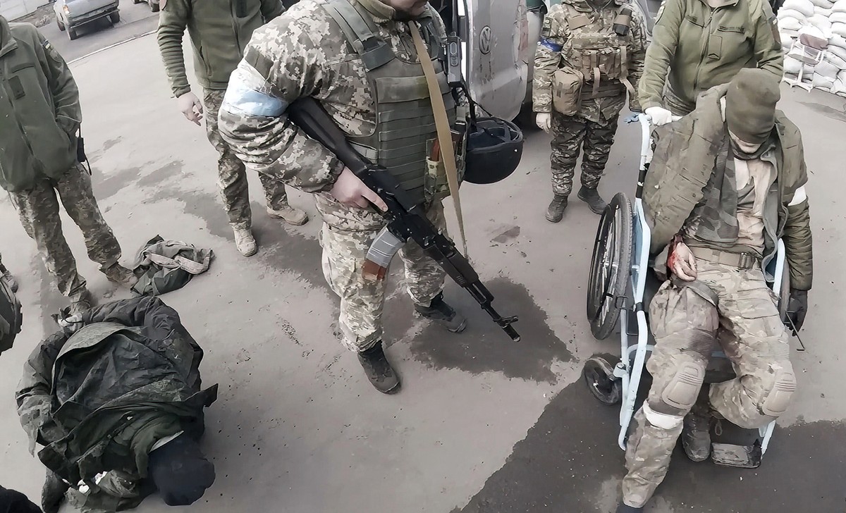Two injured Russian soldiers, left and right, arrive at a hospital to be treated on March 10, 2022, in Mariupol, Ukraine. "They will not be as kind to us as we'll be to them," Yuliia Pa ...
