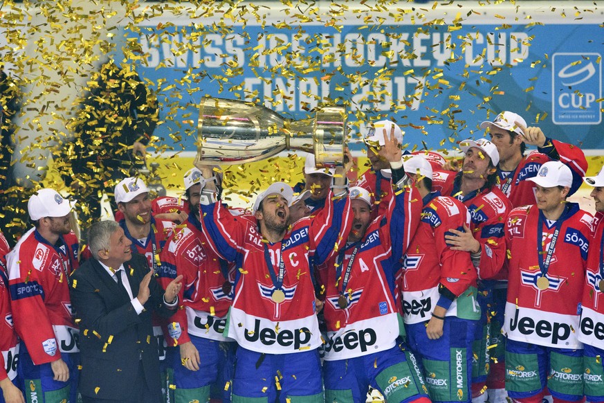 Kloten&#039;s forward Denis Hollenstein, center, celebrates with the trophy and teamates after winning the Swiss Ice Hockey Cup final game between EHC Kloten and Geneve-Servette HC, at the SWISS Arena ...