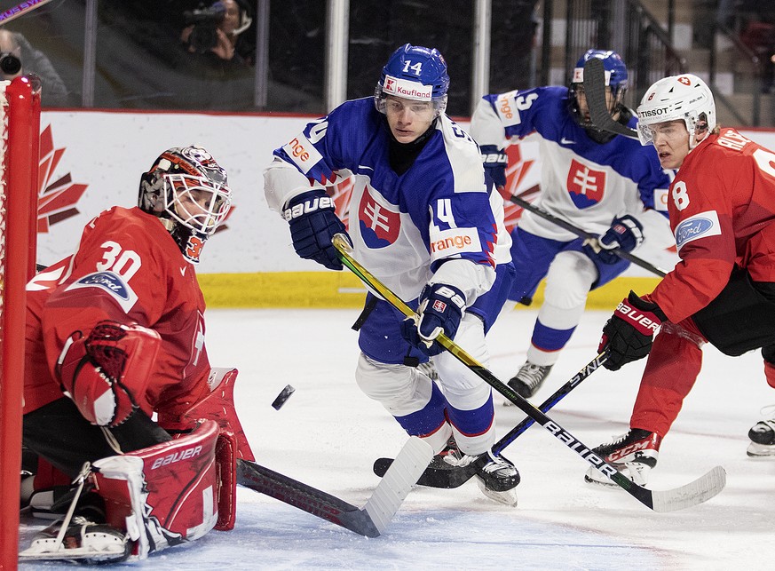 Slovakia&#039;s Adm Sykora, center, looks for the rebound from Switzerland goaltender Kevin Pasche as Switzerland&#039;s Mats Alge defends during the first period of a preliminary round game at the wo ...