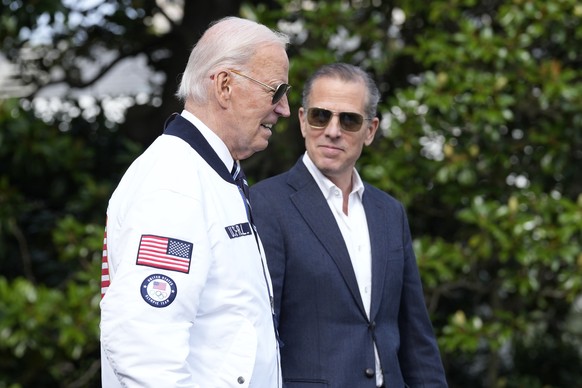 FILE - President Joe Biden, wearing a Team USA jacket and walking with his son Hunter Biden, heads toward Marine One on the South Lawn of the White House in Washington, July 26, 2024. (AP Photo/Susan  ...