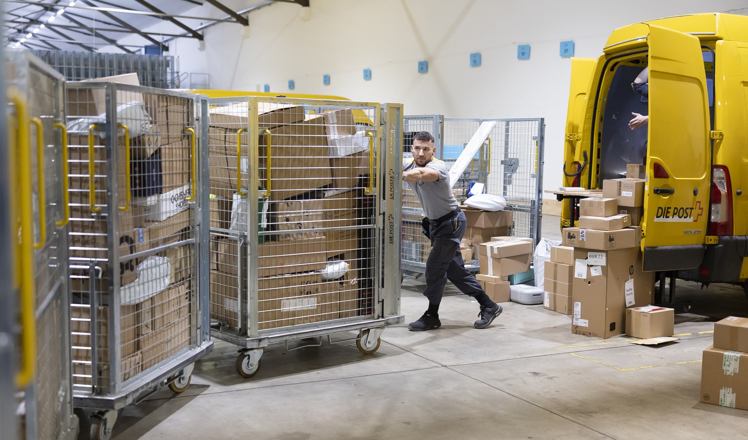 Der Paketbote der Schweizerischen Post Aron Moldovan sortiert mit anderen Paketboten Pakete zum Beladen der Lieferwagen fuer die Zustellung, in der Distributionsbasis Frauenfeld, am Dienstag, 13. Deze ...