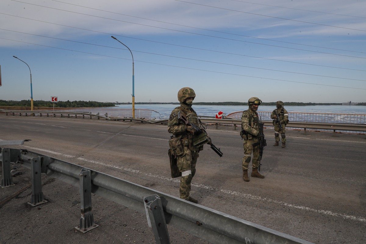 epa09962108 A picture taken during a media tour organized by the Russian Army shows Russian servicemen standing guard near the Kakhovka Hydroelectric Power Plant (HPP) on the Dnieper River in Kakhovka ...