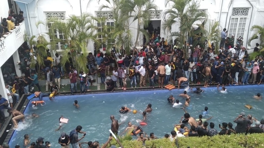 Anti government protesters swim in a pool at the president&#039;s official residence after storming into it in Colombo, Sri Lanka, Saturday July 9, 2022. (AP Photo/STR)