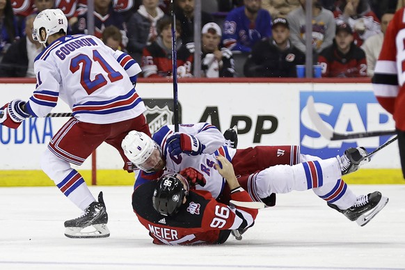 New York Rangers defenseman Jacob Trouba, top center, checks New Jersey Devils right wing Timo Meier (96) during the third period of Game 7 of an NHL hockey Stanley Cup first-round playoff series Mond ...