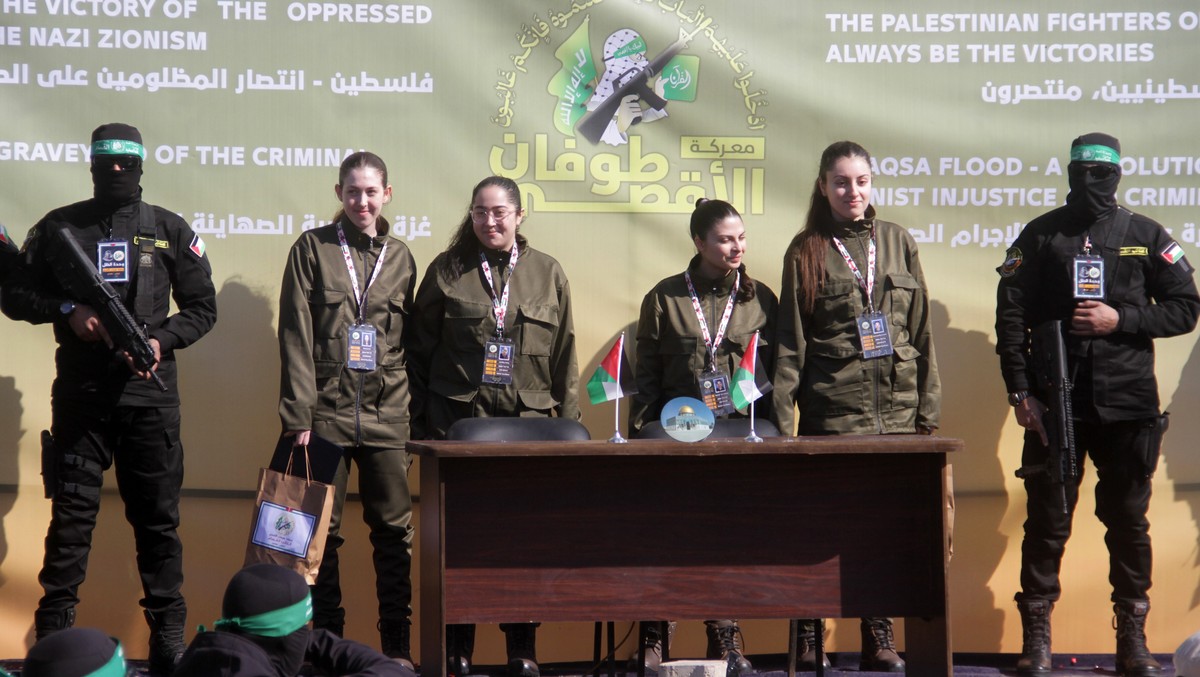 epaselect epa11851213 (L-R) Israeli hostages Naama Levy, Liri Albag, Daniella Gilboa and Karina Ariev stand on a stage before being delivered to the representative of the International Committee of th ...