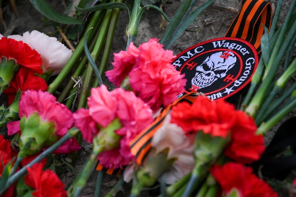 epa10817441 Flowers and a patch with the logo of PMC Wagner laid at an informal memorial next to the former &#039;PMC Wagner Centre&#039; in St. Petersburg, Russia, 24 August 2023. An investigation wa ...