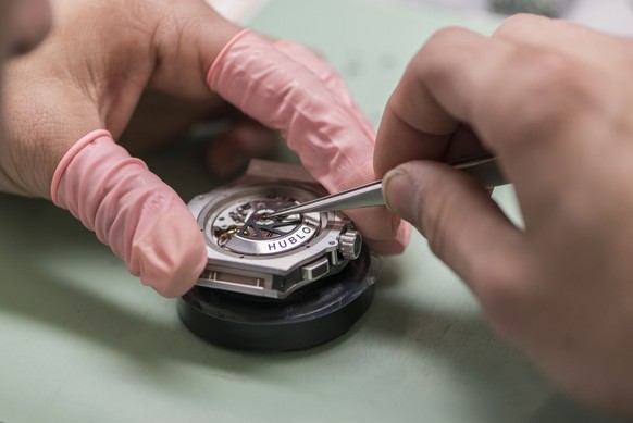 A watchmaker makes a watch, pictured at Swiss luxury watches manufacturer Hublot in Nyon, canton of Vaud, Switzerland, on March 6, 2014. (KEYSTONE/Christian Beutler)

Ein Uhrmacher baut eine Uhr zusam ...