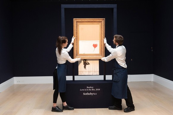 News Themen der Woche KW41 News Bilder des Tages 181012 -- LONDON, Oct. 12, 2018 -- Sotheby s staff members present Banksy s Love is in the Bin in London, Britain on Oct. 12, 2018. Originally titled G ...