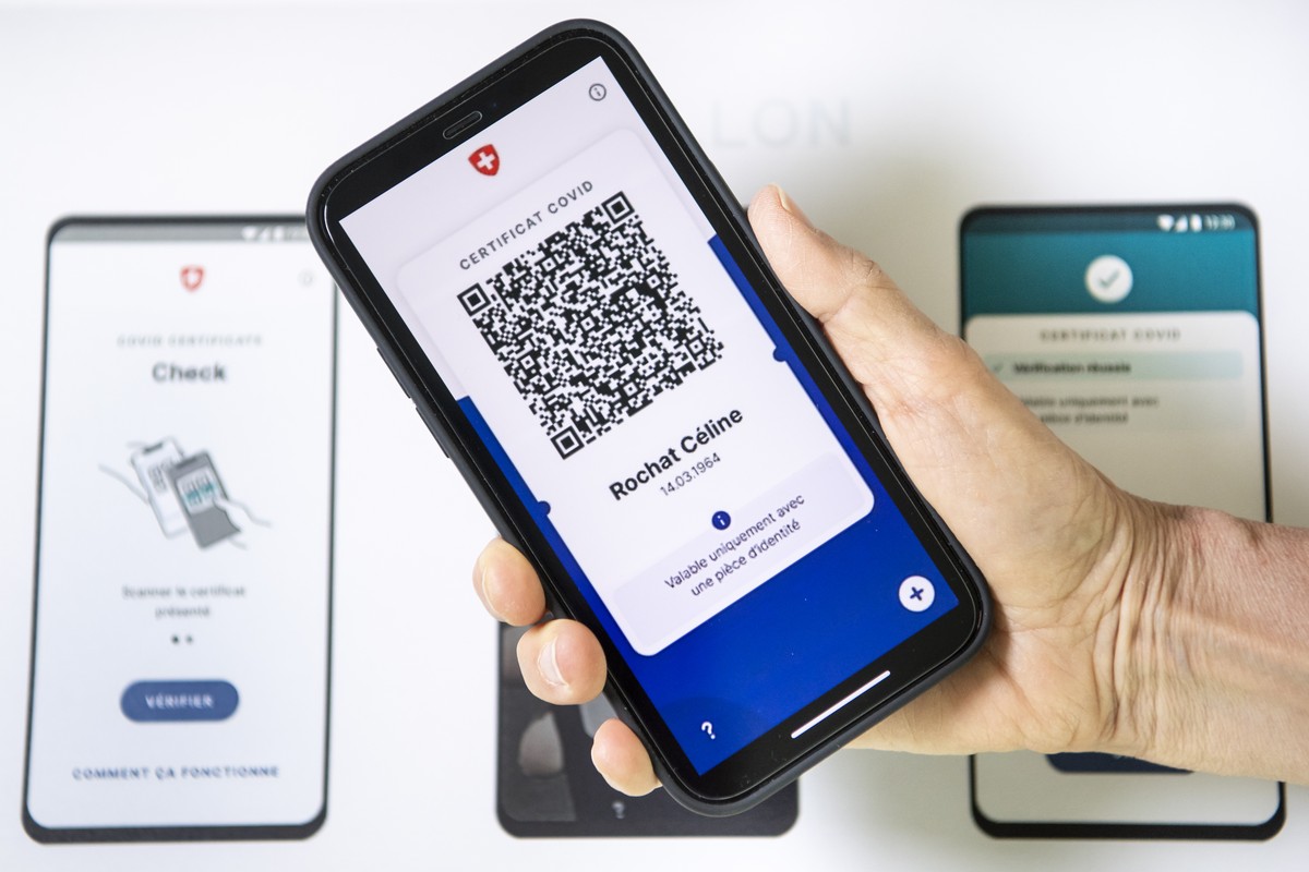 Un smartphone est visible a cote d'un visuel presentant un specimen de l'aspect du nouveau certificat Covid le vendredi 4 juin 2021 a Lausanne. Le Conseil federal presente aujourd'hui e ...