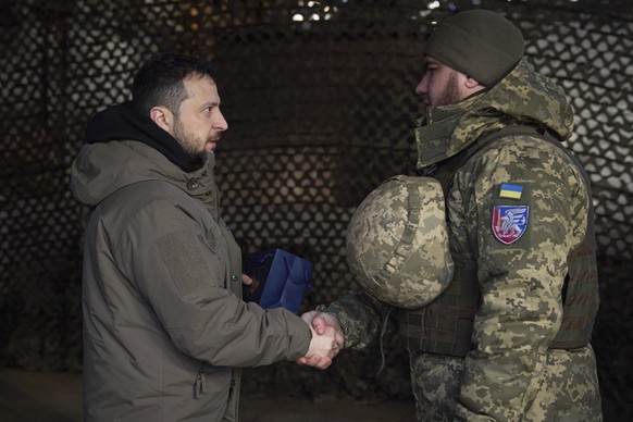 In this photo provided by the Ukrainian Presidential Press Office, Ukrainian President Volodymyr Zelenskyy, left, awards a serviceman during his visit to Sloviansk, Donbas region, Ukraine, Tuesday, De ...