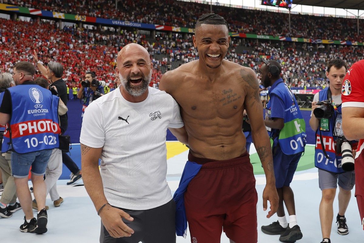 Switzerland's assistant coach Giorgio Contini, left, and Manuel Akanji celebrate after winning 2:0 against Italy after a round of 16 match between Switzerland and Italy at the Euro 2024 soccer to ...