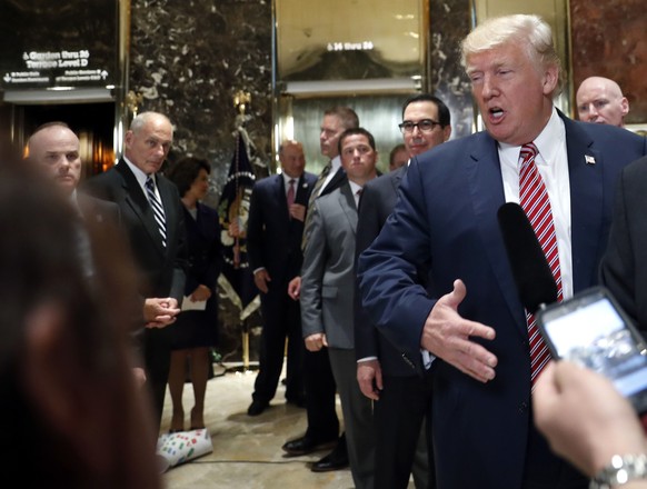 White House chief of staff John Kelly, left, watches as President Donald Trump speaks to the media in the lobby of Trump Tower, Tuesday, Aug. 15, 2017 in Washington. (AP Photo/Pablo Martinez Monsivais ...