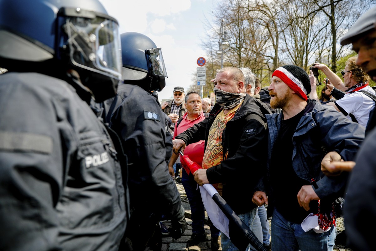 Police officers argues with demonstrators after police stop a protest rally against the German government's policy to battle the corona virus pandemic in Berlin, Germany, Wednesday, April 21, 202 ...