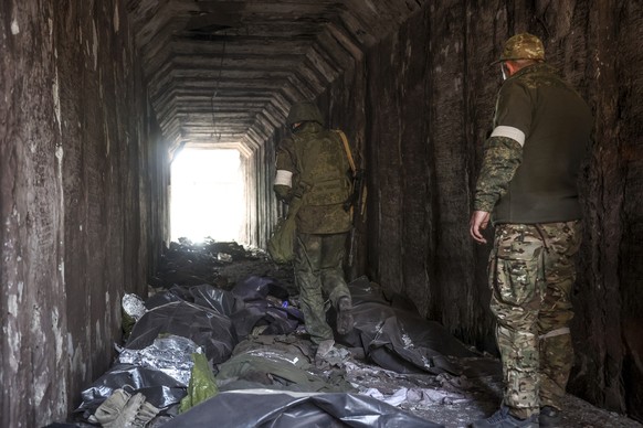 Servicemen of the Donetsk People&#039;s Republic militia look at bodies of Ukrainian soldiers placed in plastic bags in a tunnel, part of the Illich Iron &amp; Steel Works Metallurgical Plant, the sec ...