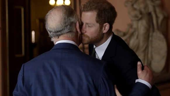 Britain's Prince Harry kisses and greets his father Prince Charles upon their separate arrival to attend a coral reef health and resilience meeting with speeches and a reception with delegates at ...