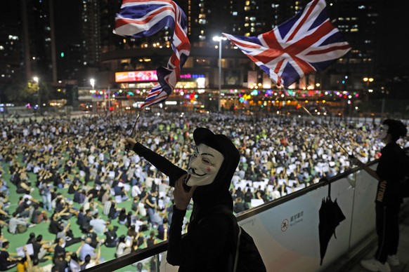 Anti-government protesters carry British flags as residents gather to protest a teenage demonstrator shot at close range in the chest by a police officer and condemn police tactics and demand accounta ...