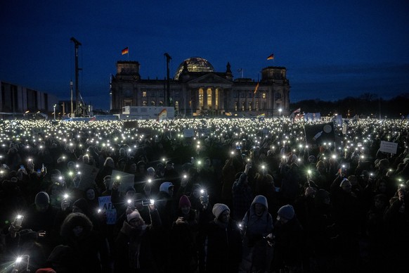 People gather to protest against the AfD party and right-wing extremism in front of the Reichstag building in Berlin, Germany, Sunday, January 21, 2024. (AP Photo/Ebrahim Noroozi)